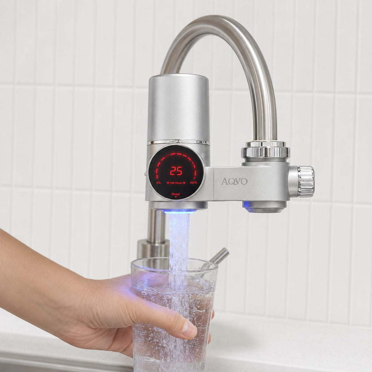 AQVO tap filter filling a glass, with the filter-life display lit while water flows